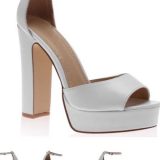 נעל פלטפורמה לבנה עם עקבים גבוהים, פתוחה המוצגת מזוויות שונות. לנעל עקב עבה וגימור חלק. חיצים שחורים נראים בצדדים, המציינים תכונה של הצגת שקופיות.